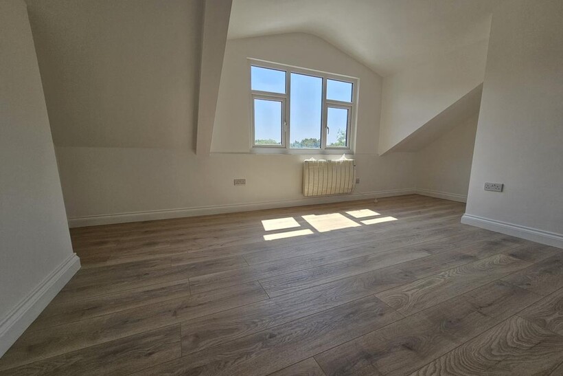 Bright top-floor bedroom with light wood floori...