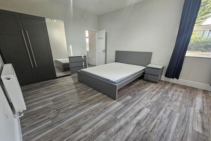 Bright, modern double bedroom with a large wind...