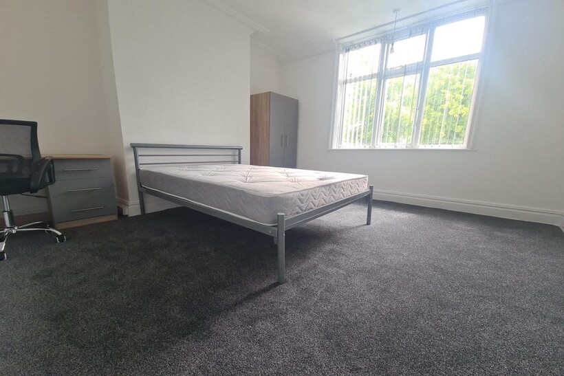 A bright and tidy bedroom featuring a double be...