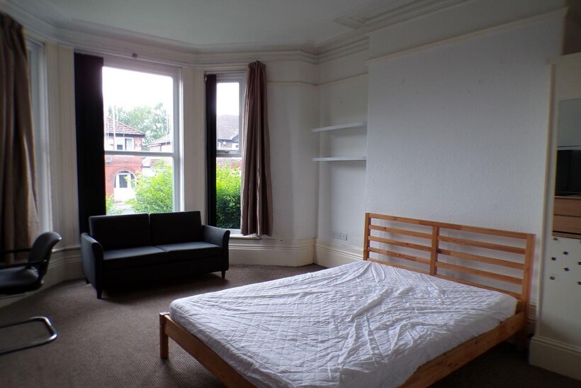 Bright double bedroom with large bay windows, a...