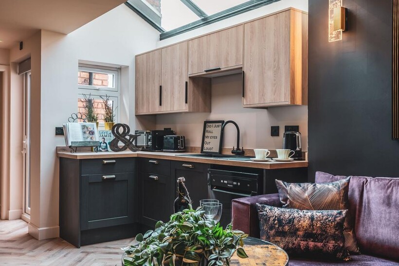 Stylish open-plan kitchen area with light wood ...