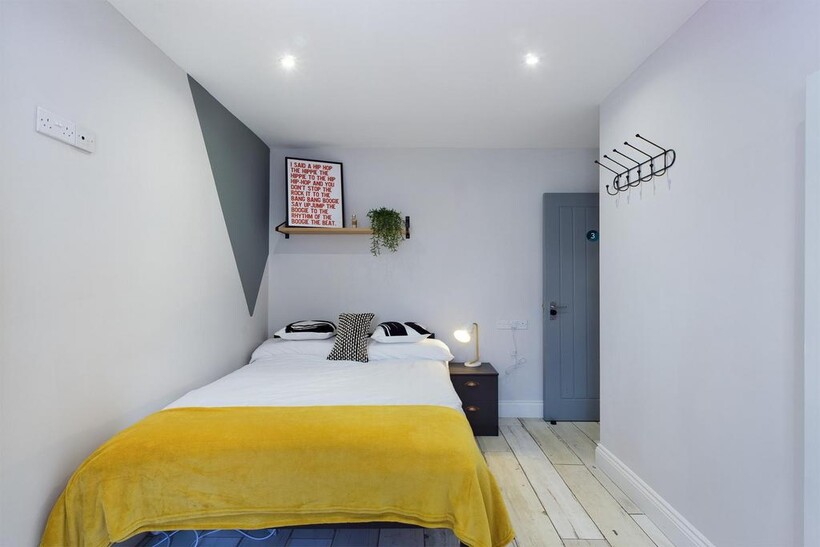 A bright and tidy double bedroom featuring mode...