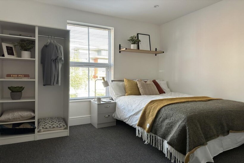 A bright and inviting double bedroom with styli...