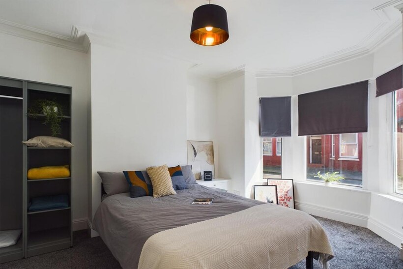 A bright and inviting double bedroom with styli...