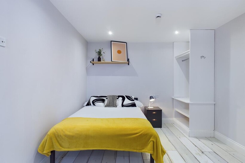 A bright and tidy bedroom featuring a comfortab...