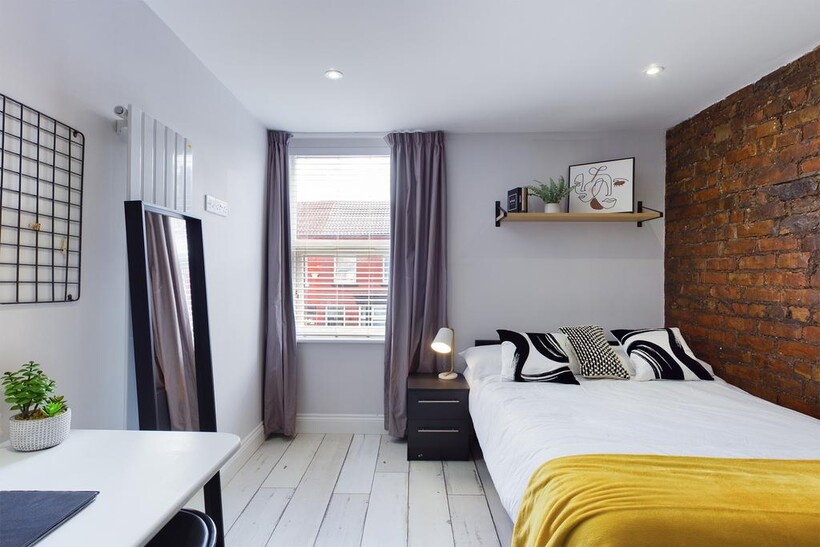 A bright and inviting bedroom featuring a comfo...