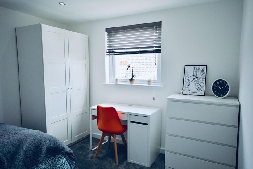 A well-lit, modern bedroom featuring a wardrobe...