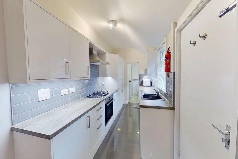 Bright modern galley kitchen with glossy tiled ...