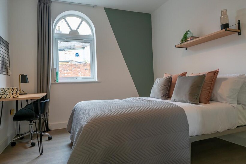 A bright and stylish double bedroom with a cozy...