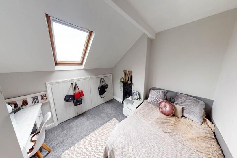 A bright, spacious master bedroom with a cozy b...