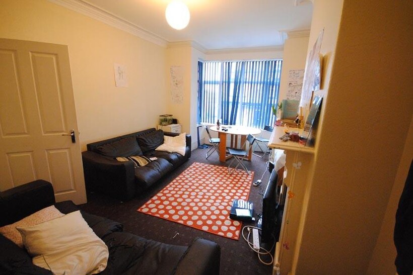 A cozy, well-lit living room featuring comforta...