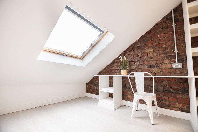 Bright loft bedroom with a large skylight, expo...