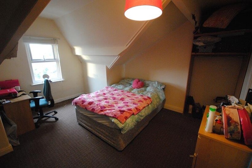 A cozy, well-lit bedroom featuring a large doub...