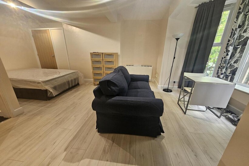 Spacious and well-lit bedroom featuring a comfo...