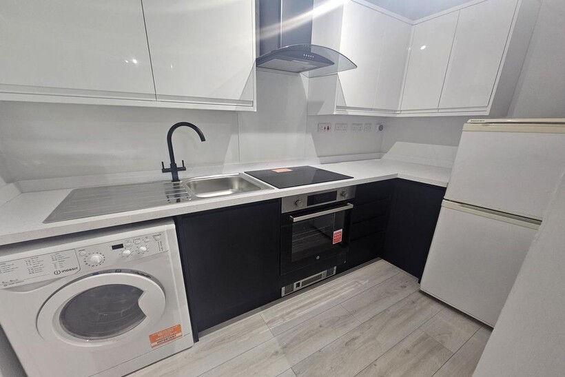 Modern kitchen with sleek black and white cabin...