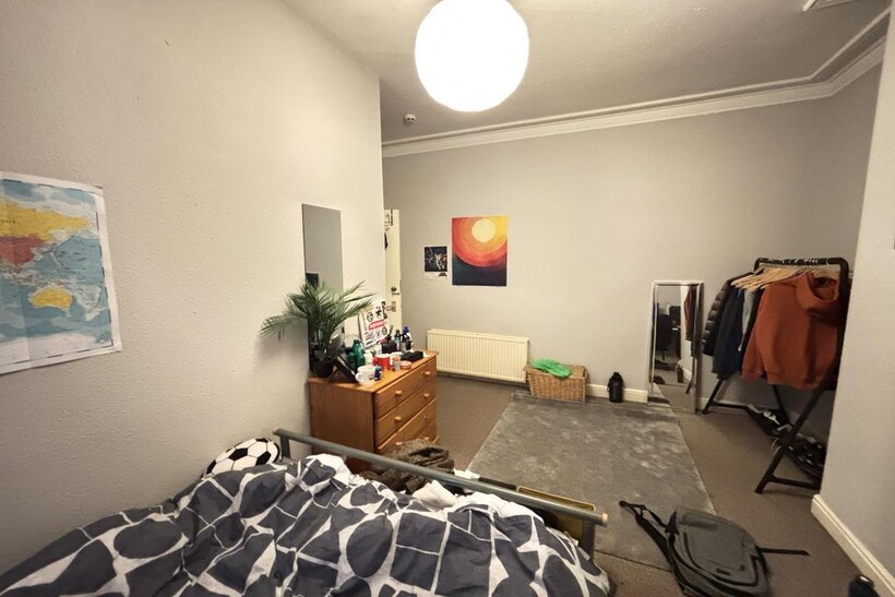 A tidy bedroom featuring a modern bed with a pa...