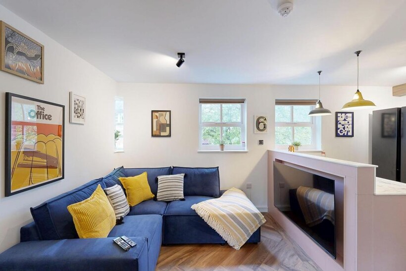 Bright, modern living room with a deep blue L-s...