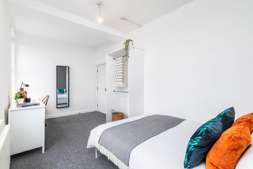 A clean and bright single bedroom featuring a c...