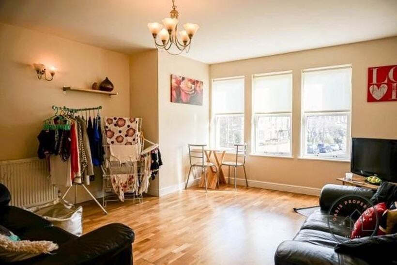 A bright and spacious living room featuring lar...