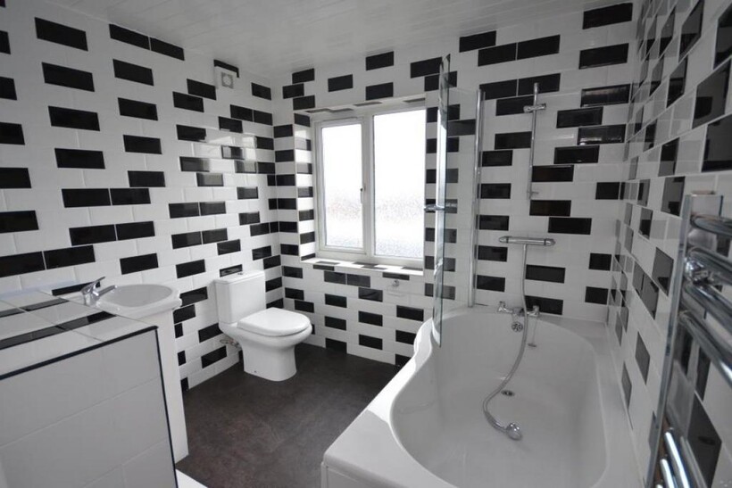 Modern bathroom featuring geometric black and w...