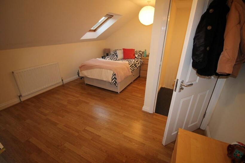 A bright and welcoming bedroom featuring a larg...