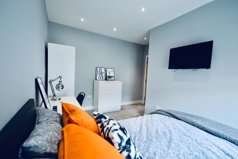 A spacious and well-lit bedroom featuring a lar...