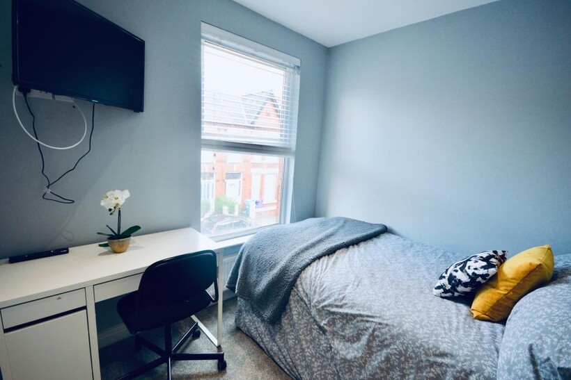 A bright, neatly arranged bedroom featuring a s...