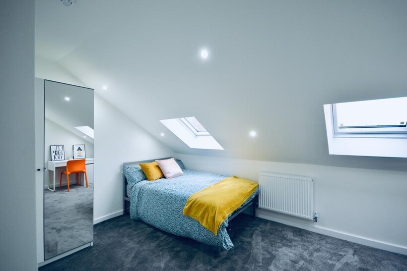 A bright, modern bedroom featuring a double bed...