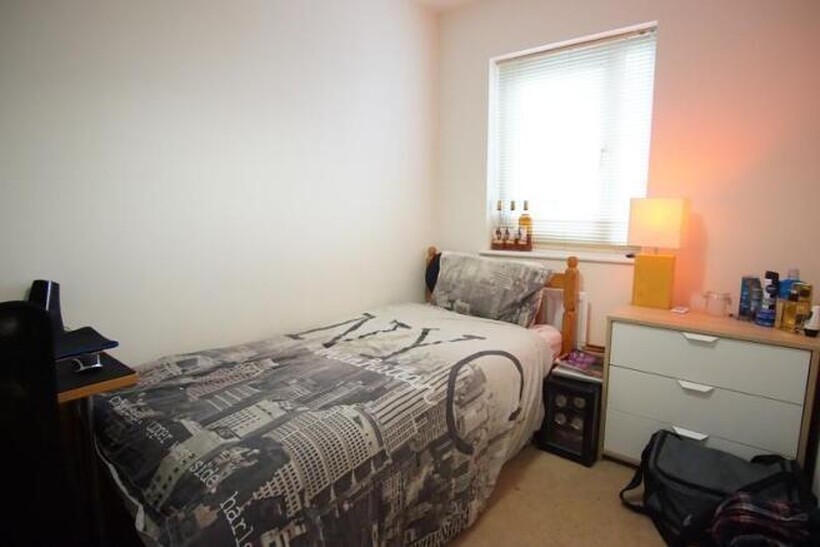 A well-lit, comfortably furnished master bedroo...