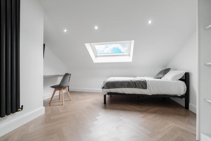 A spacious, modern master bedroom featuring a c...