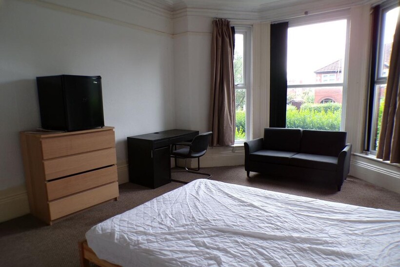 Bright bay-fronted master bedroom with large wi...