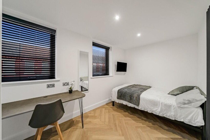 A bright and tidy student bedroom featuring a s...