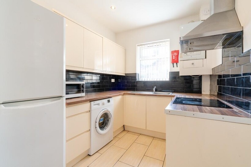 Bright and clean kitchen featuring white cabine...