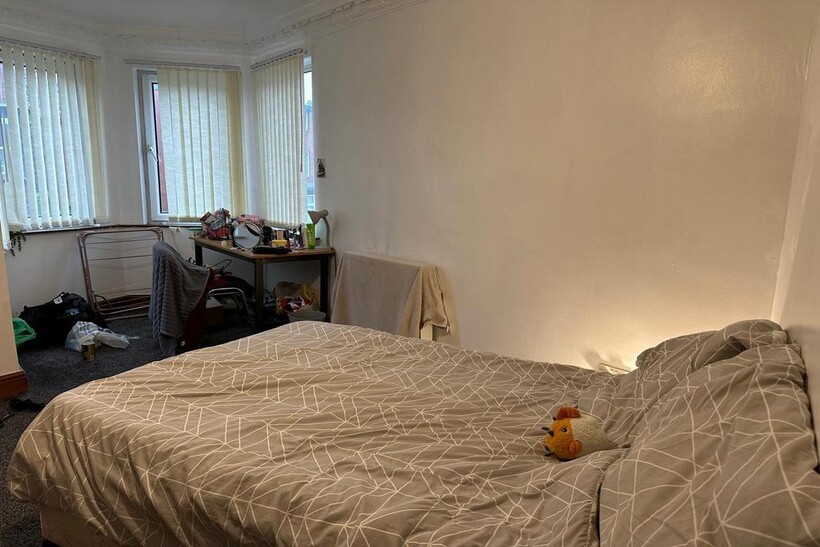 A cozy bedroom featuring a comfortably made dou...