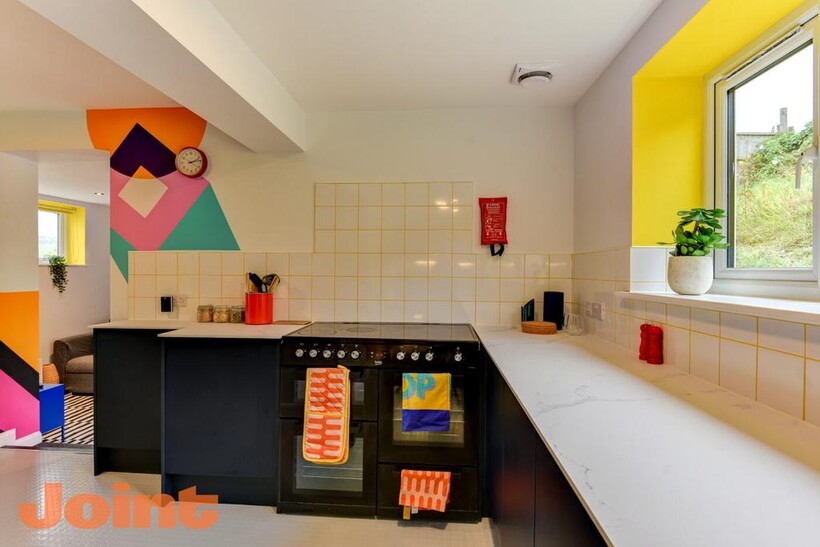 Bright and modern kitchen featuring a large win...