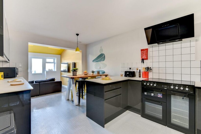 Bright modern kitchen with glossy dark cabinets...