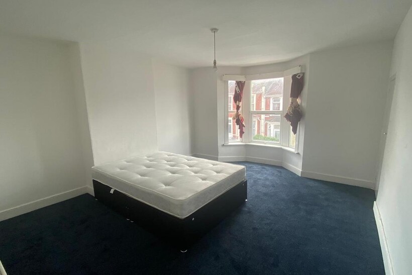 A bright double bedroom featuring a large bay w...