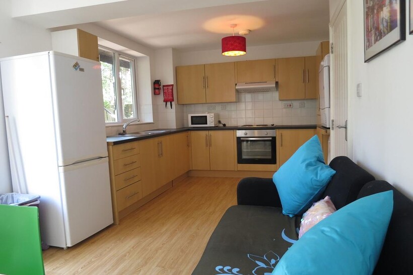 Bright open-plan kitchen with light wood cabine...