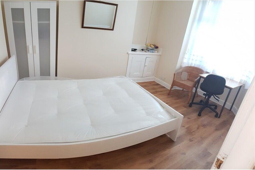 Bright, simply styled bedroom with a double bed...