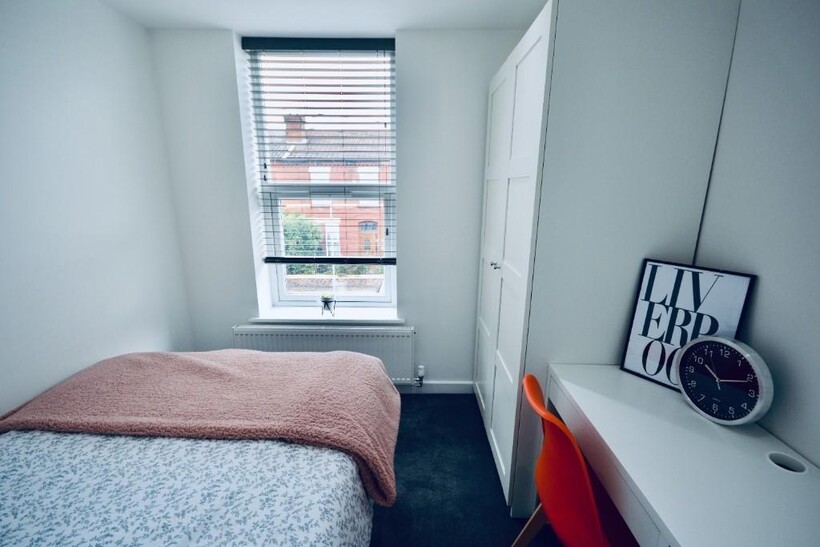 A bright and cozy single bedroom featuring a ne...