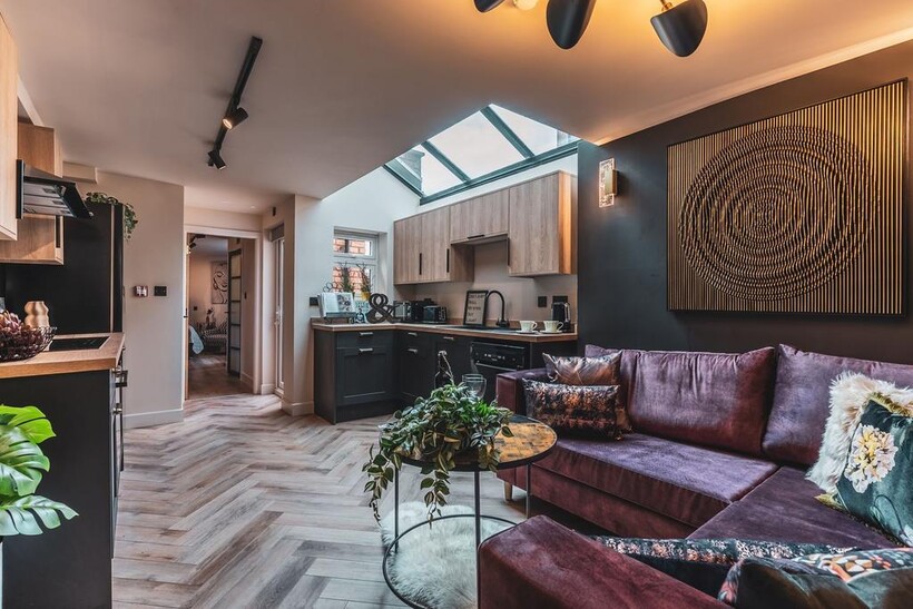 Stylish open-plan living area with a plush purp...