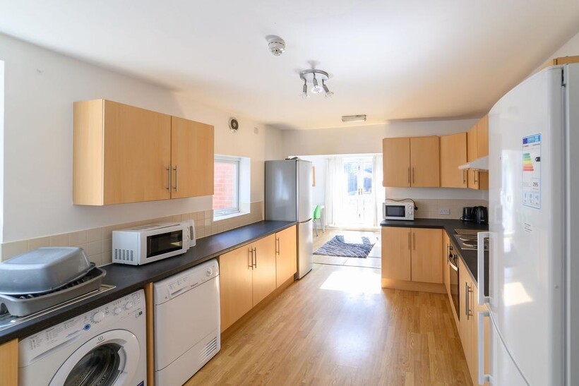 Bright, modern galley kitchen with light wood c...