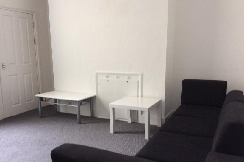 A modern living room featuring a black sofa, a ...