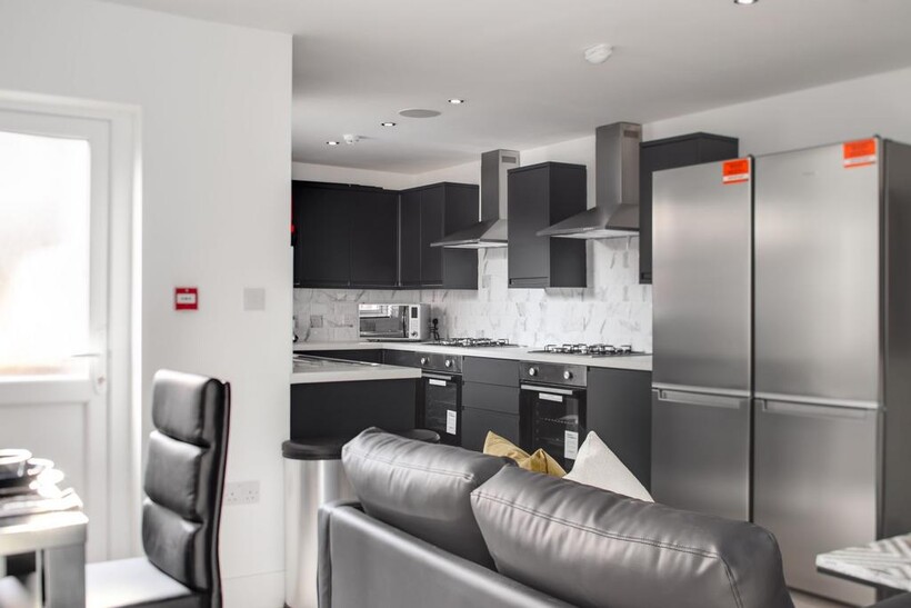 Modern and sleek kitchen featuring dark cabinet...