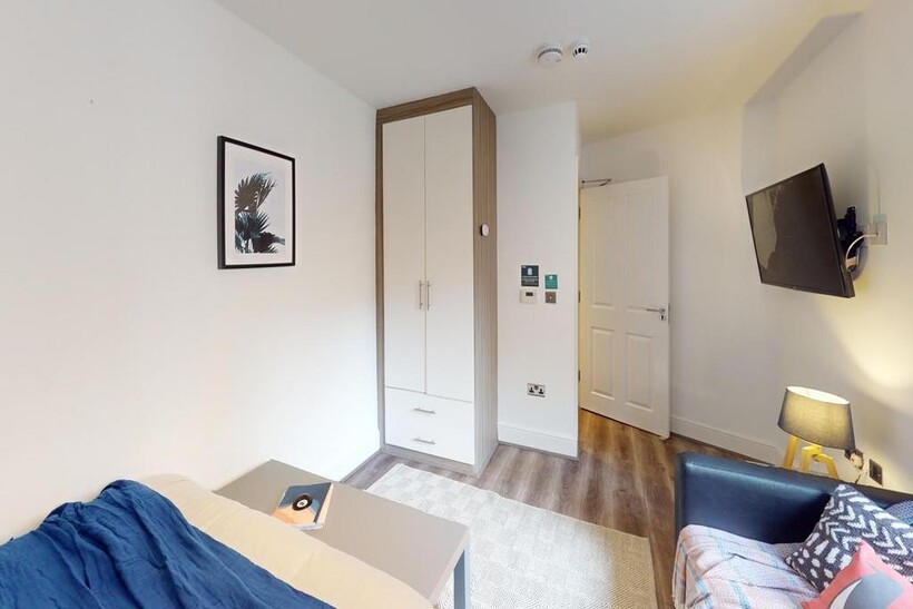 A bright and tidy double bedroom featuring mode...