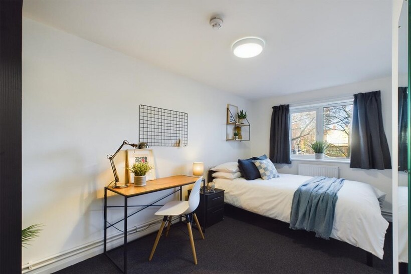A bright and inviting double bedroom with a sty...