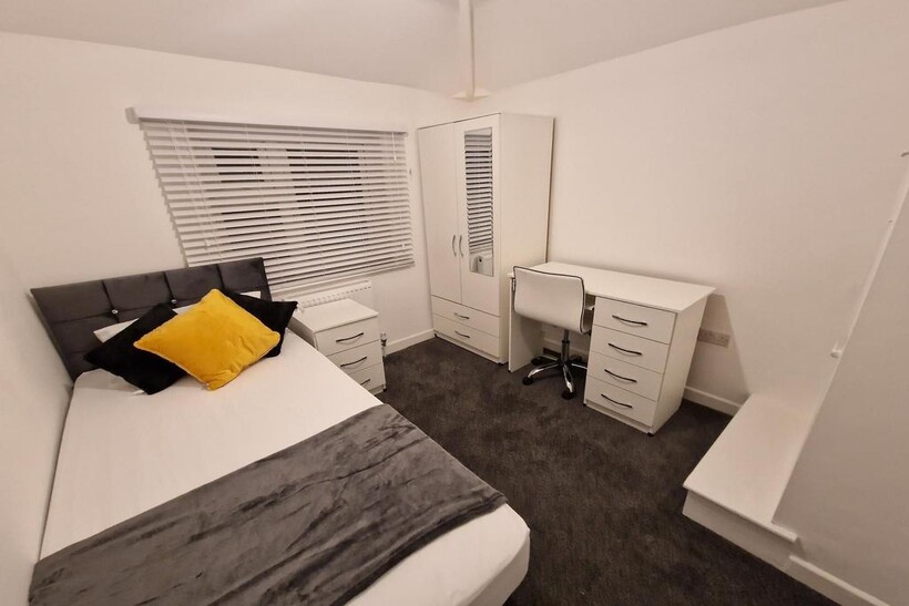 Bright, neatly furnished single bedroom with a ...