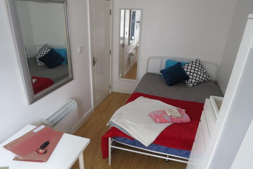 Neat, simply furnished bedroom with a single me...